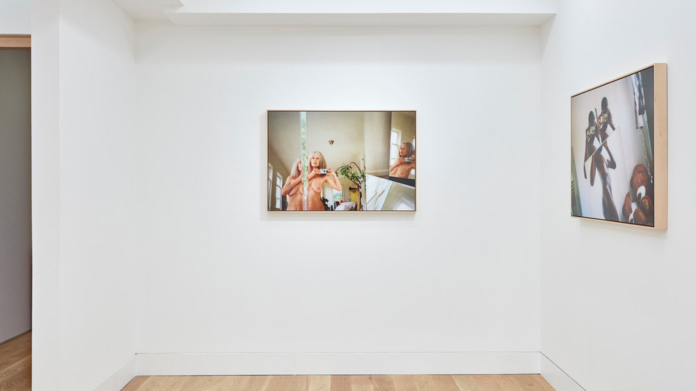 An installation view of two Ryan McGinley photographs hung on the wall. 