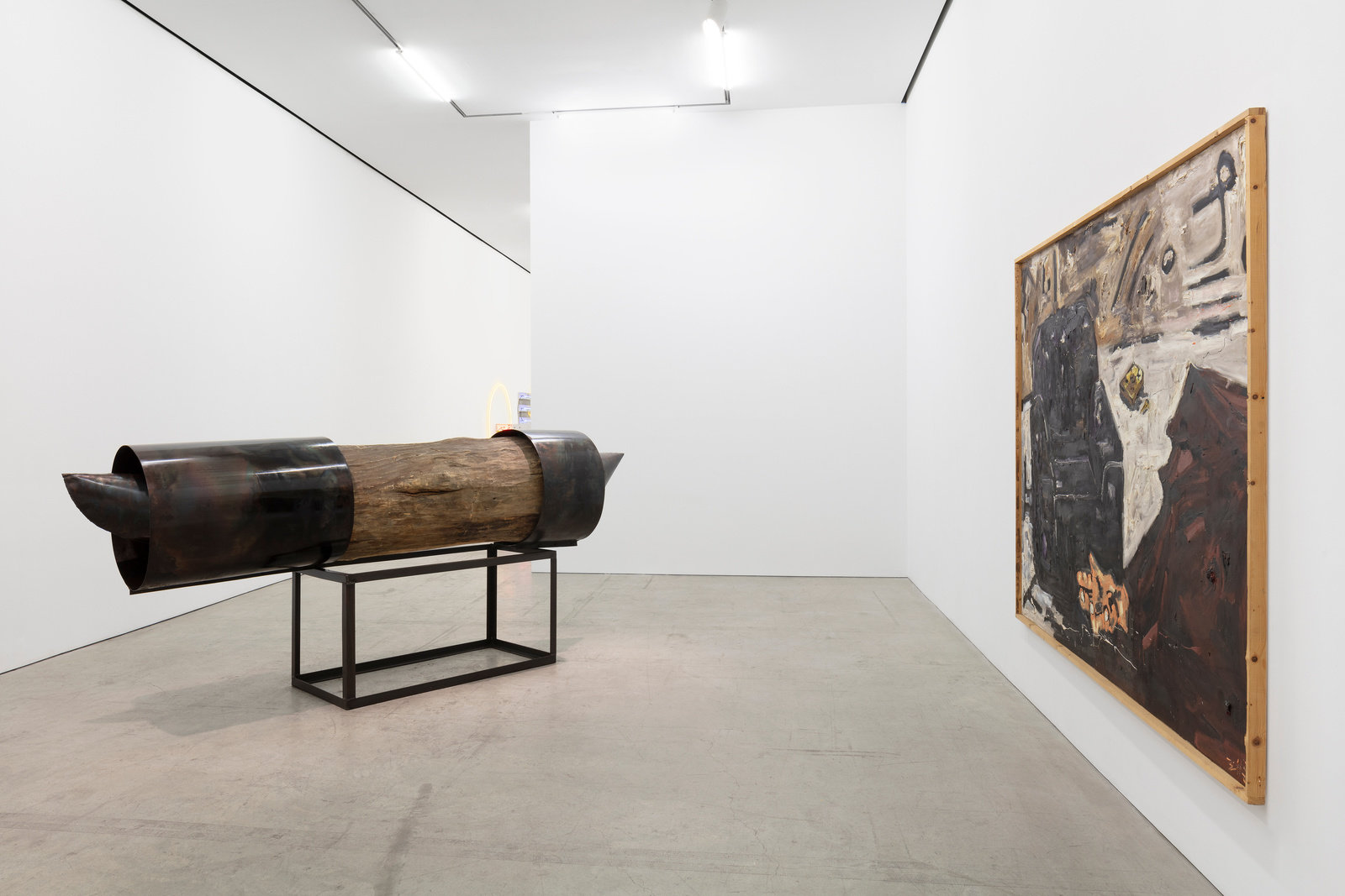 An installation view of a large wood and iron sculpture by Magdalena Abakanowicz and a Werner Büttner painting of a chair. 